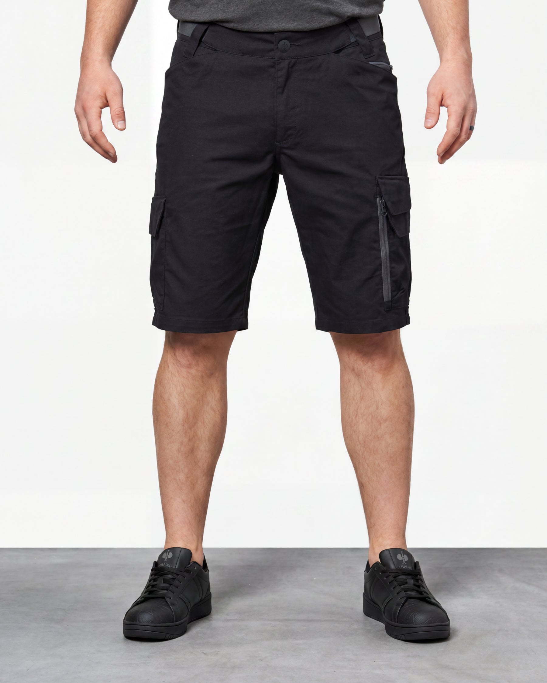 Model wearing Engelbert Strauss e.s. trail pure cargo work shorts in black and carbon gray, showing the fit, length, waistband, and front pocket layout of the two-tone cargo work shorts with reinforced utility styling.