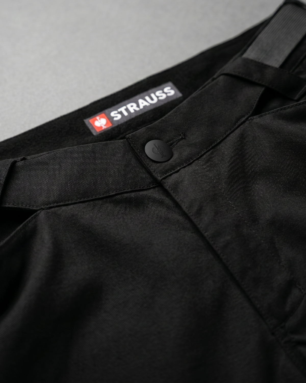 Additional close-up detail of Engelbert Strauss e.s. trail pure cargo work shorts in black and carbon gray, showing fabric texture, stitching, and functional finishing details.
