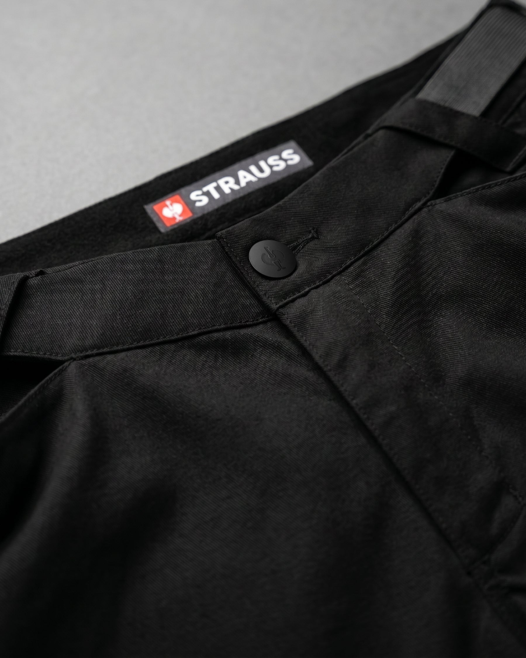 Additional close-up detail of Engelbert Strauss e.s. trail pure cargo work shorts in black and carbon gray, showing fabric texture, stitching, and functional finishing details.