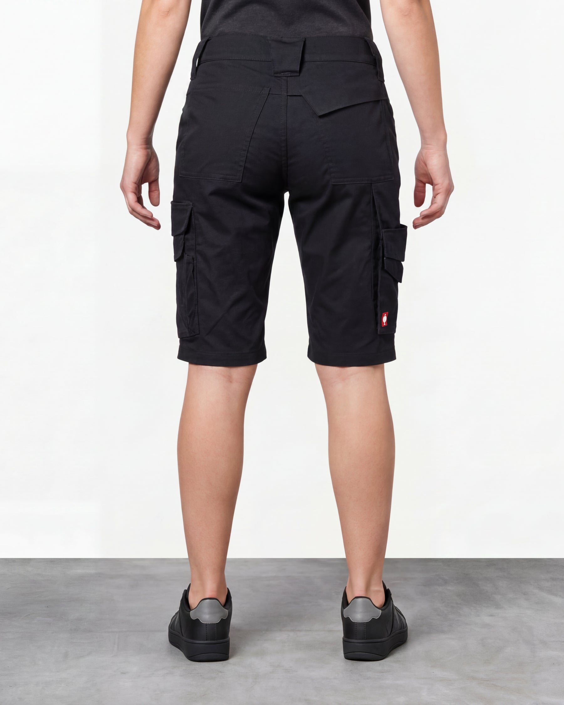 Alternate model view of Engelbert Strauss women's e.s. trail pure cargo work shorts in black and carbon gray, showing the side and back fit with visible utility pocket placement and workwear construction.