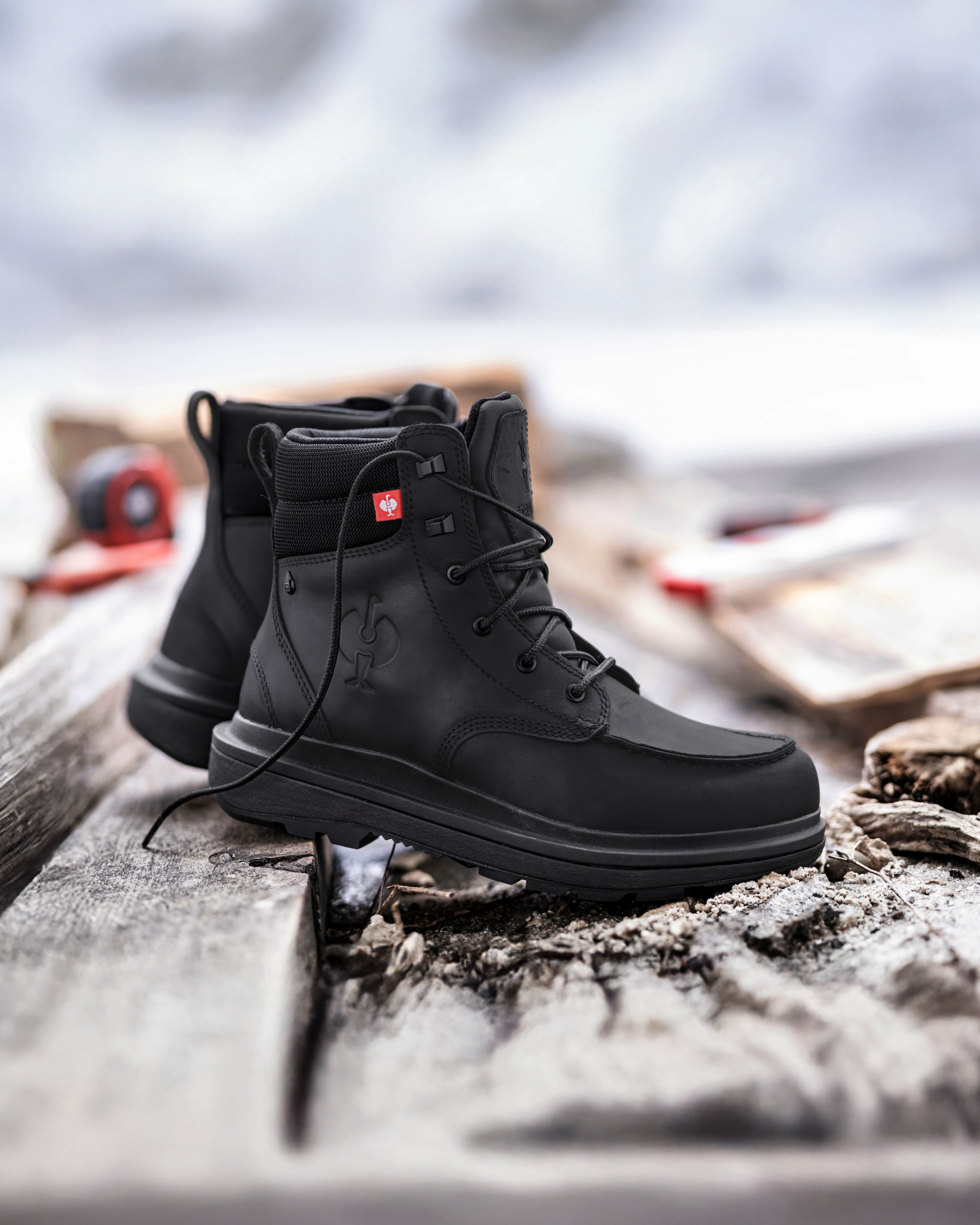 Black boots with a brand logo on a rustic background