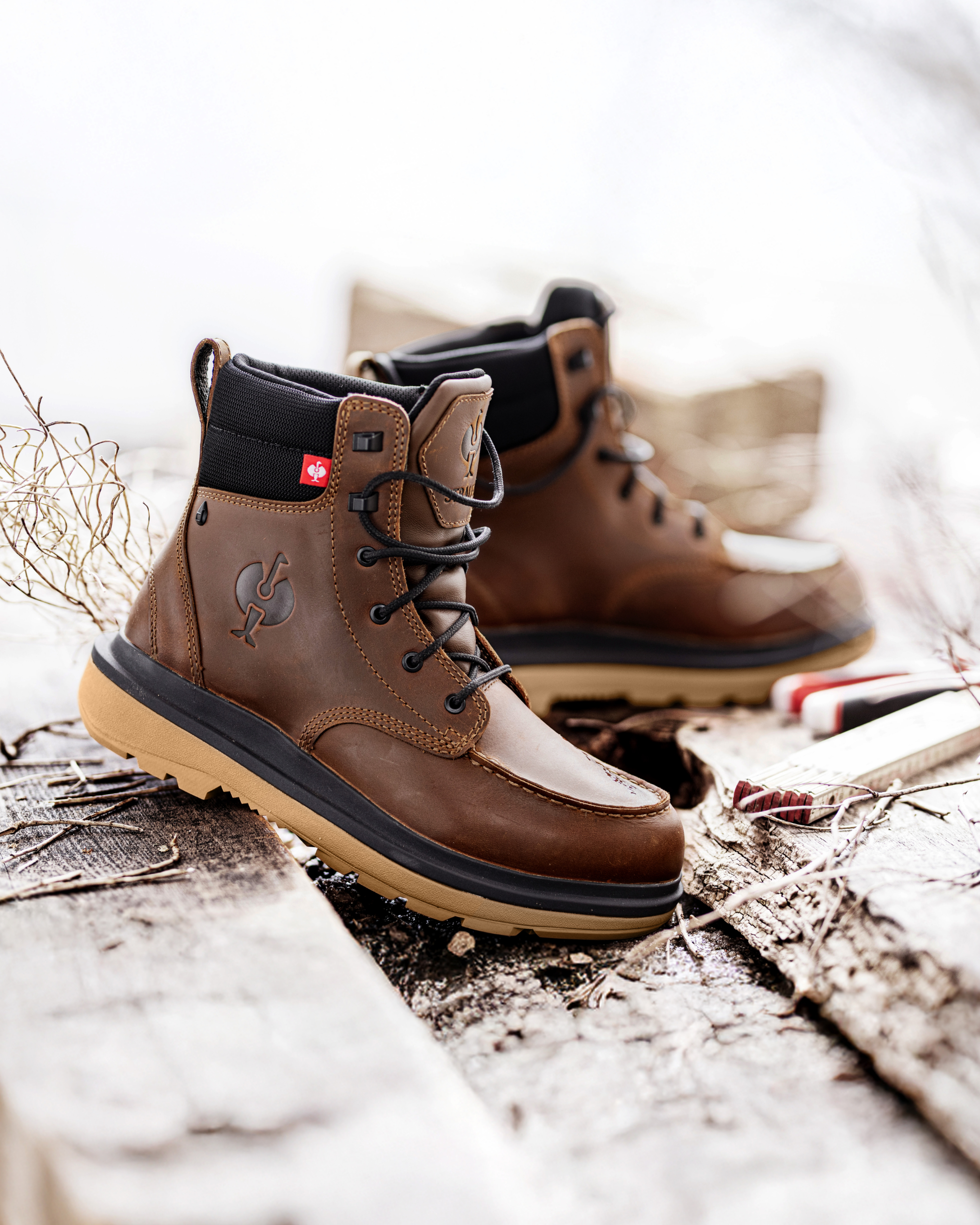 Brown work boots with brown soles on a wooden background