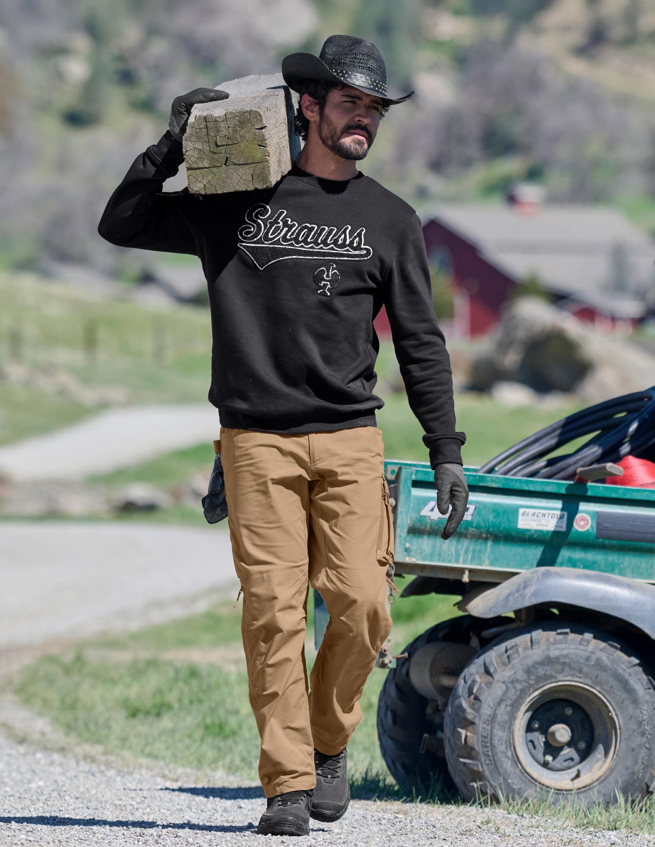 Man carrying a block of wood on his shoulder with a truck in the background