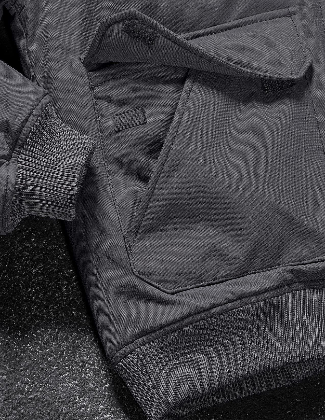 Close-up of a dark gray jacket with a focus on the collar and sleeve.
