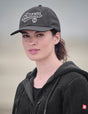 Woman wearing a dark gray cap with 'Strauss' logo on a neutral background