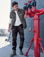 Man working on red pipes against a blue wall