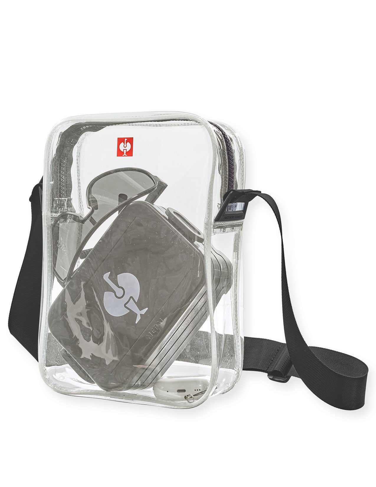 Clear crossbody bag with black strap containing a black lunch box on a white background
