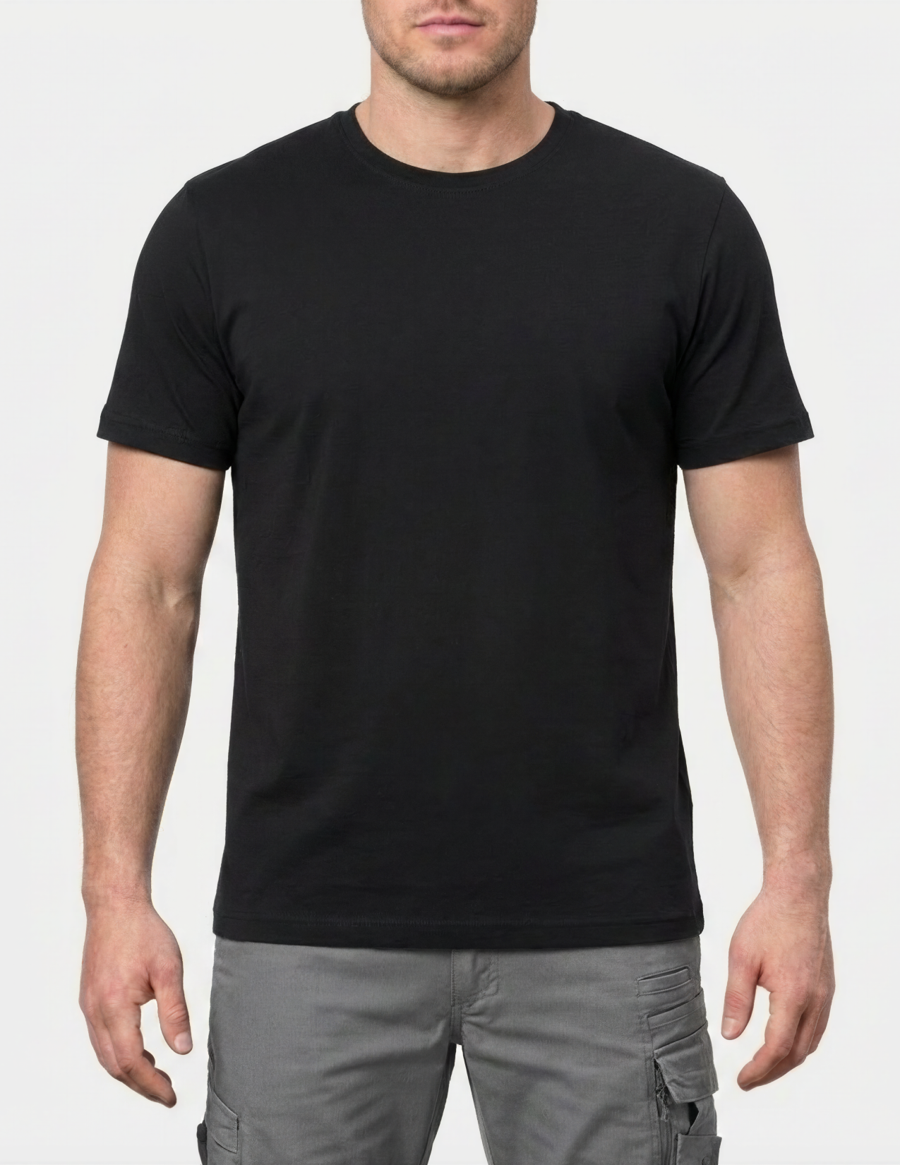 Person wearing a black t-shirt and gray pants on a white background
