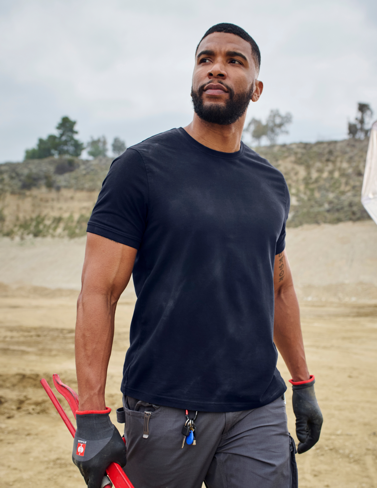 Man wearing a navy t-shirt and gray pants outdoors
