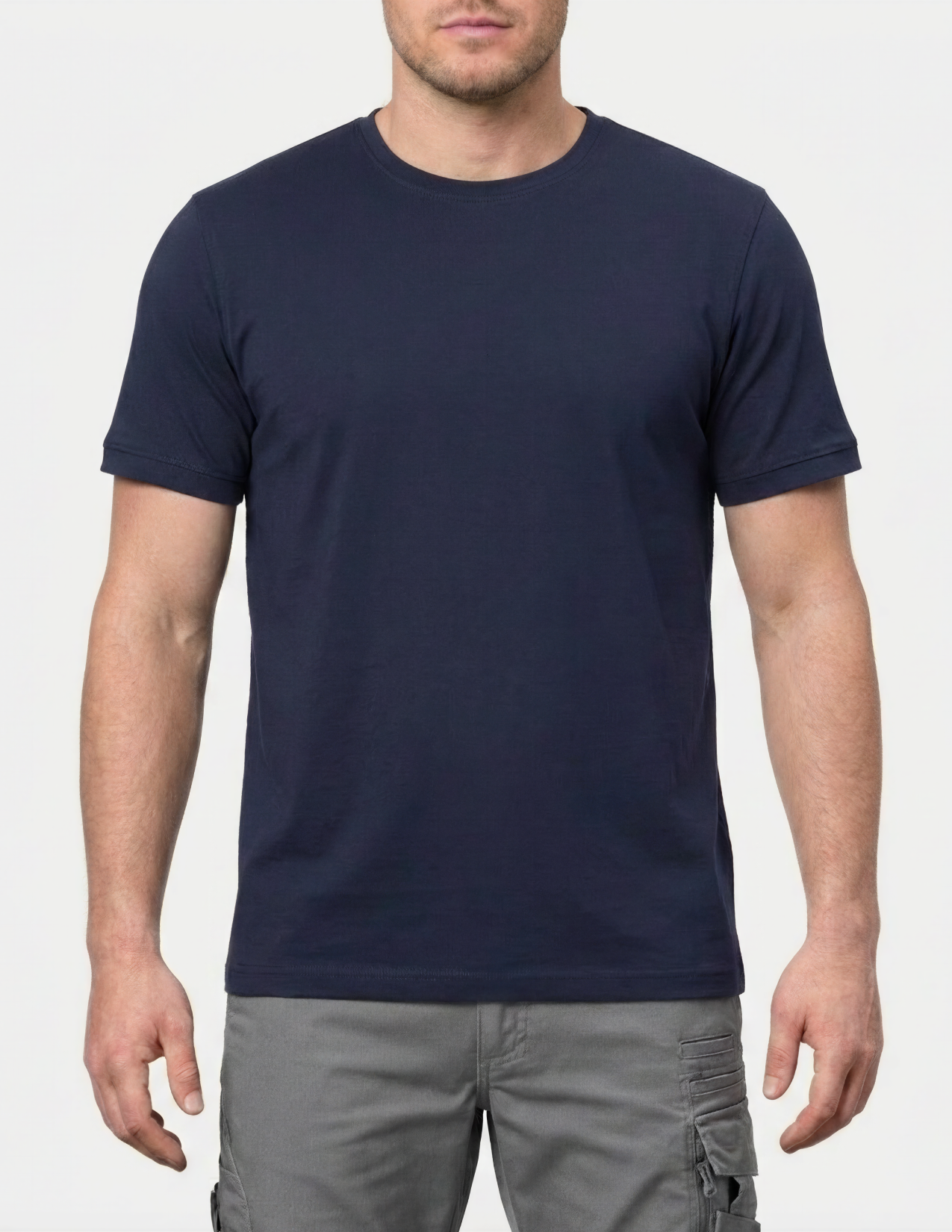Man wearing a navy blue t-shirt and gray pants on a white background