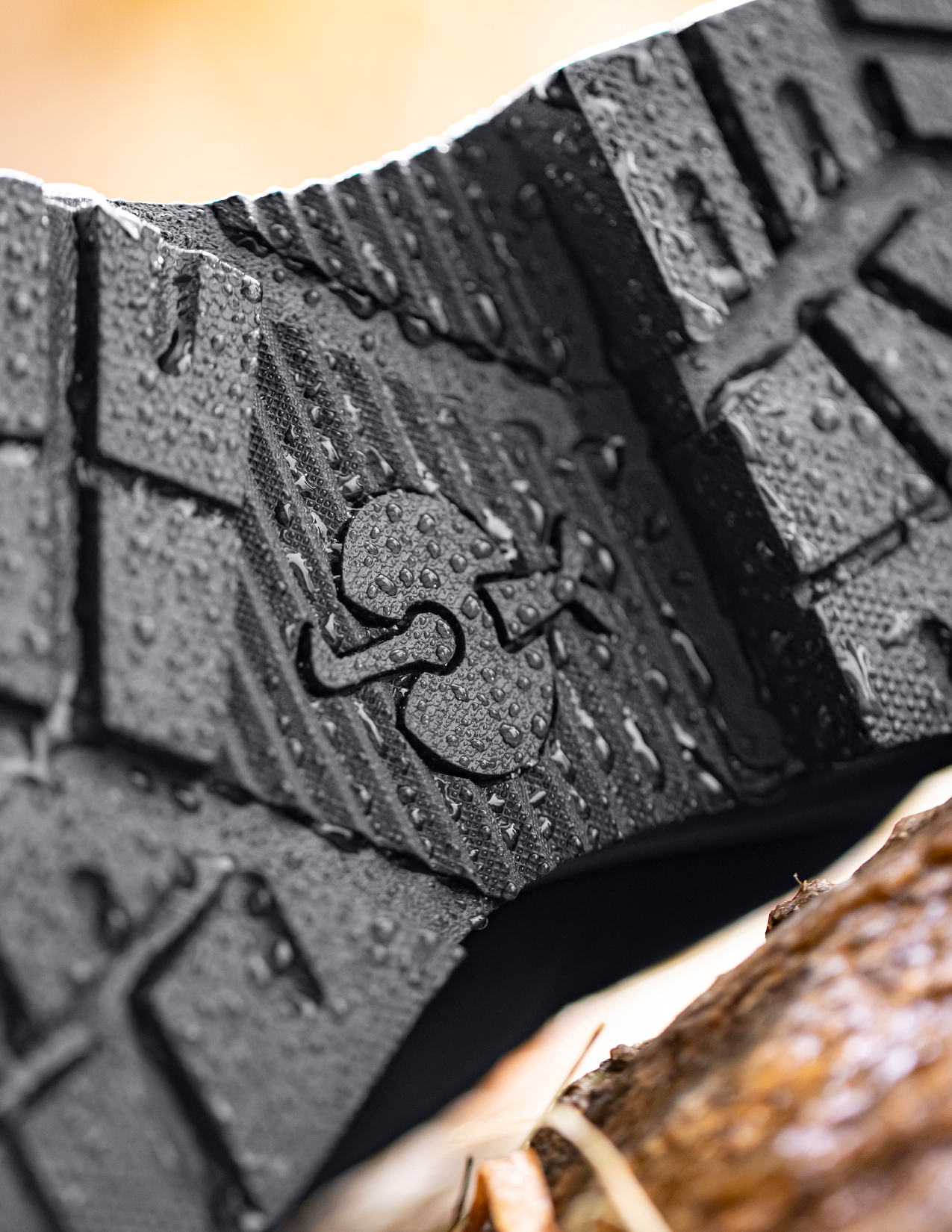 Close-up of a black rubber mat with a brand logo, showing texture and details.