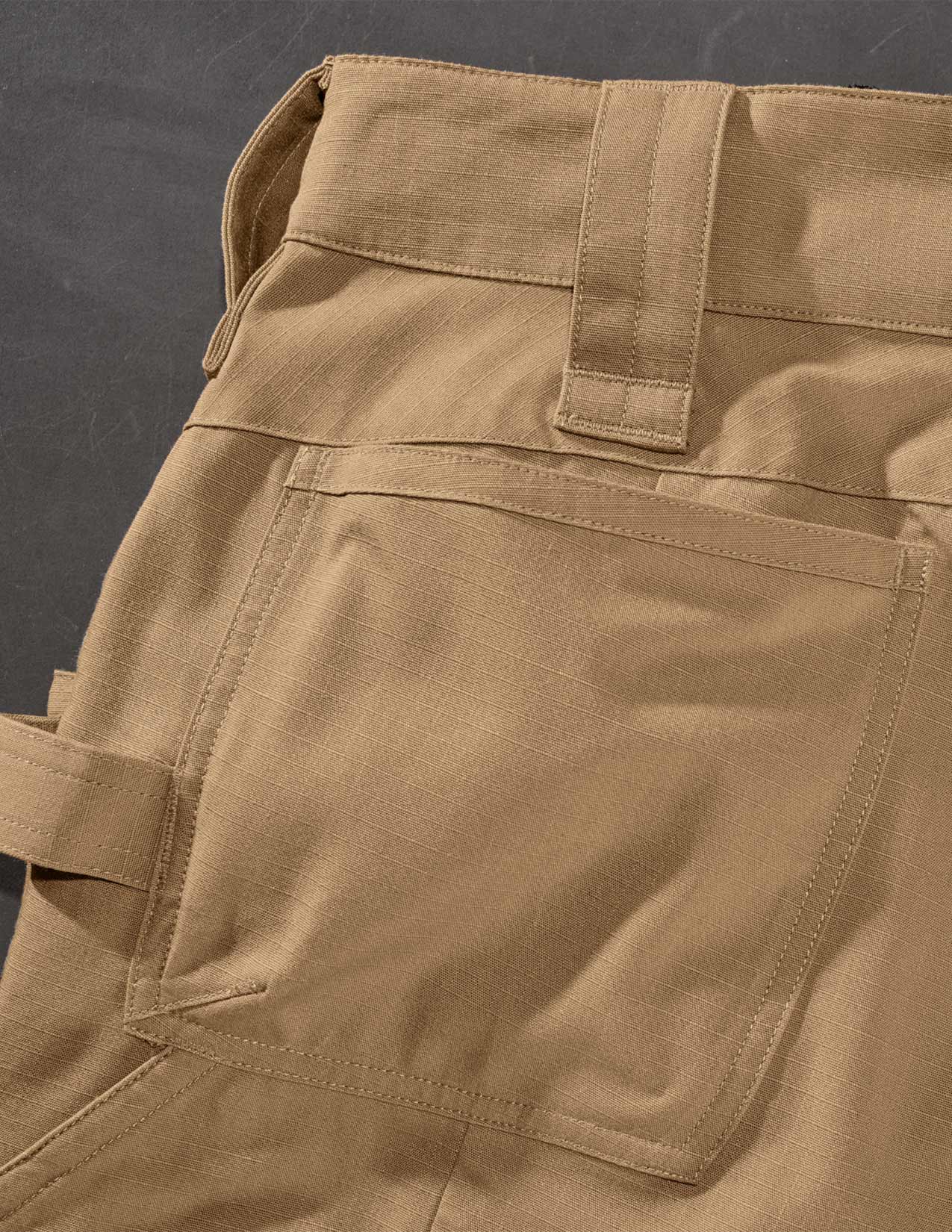 Close-up of brown pants with a dark background