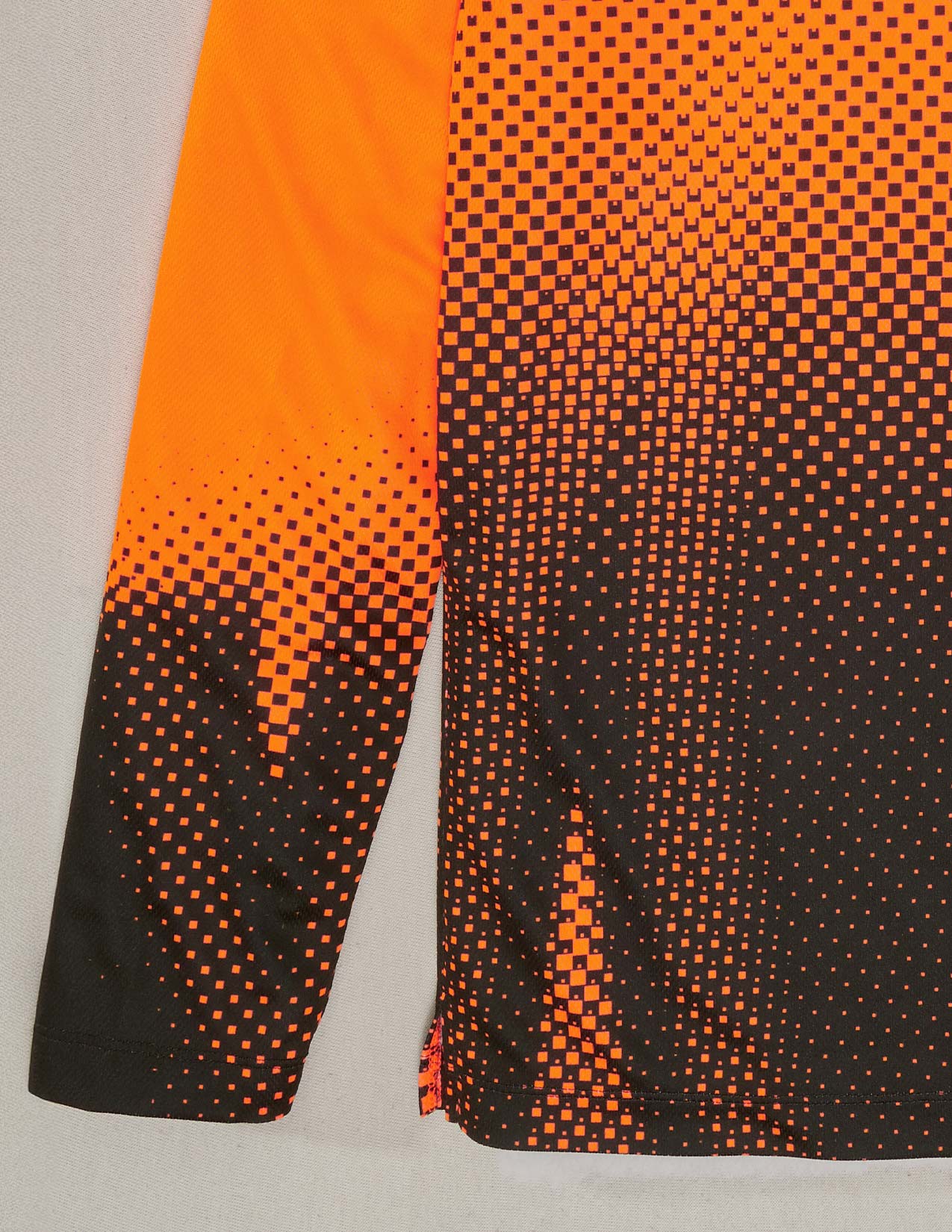 Close-up of orange and black patterned fabric on a gray background