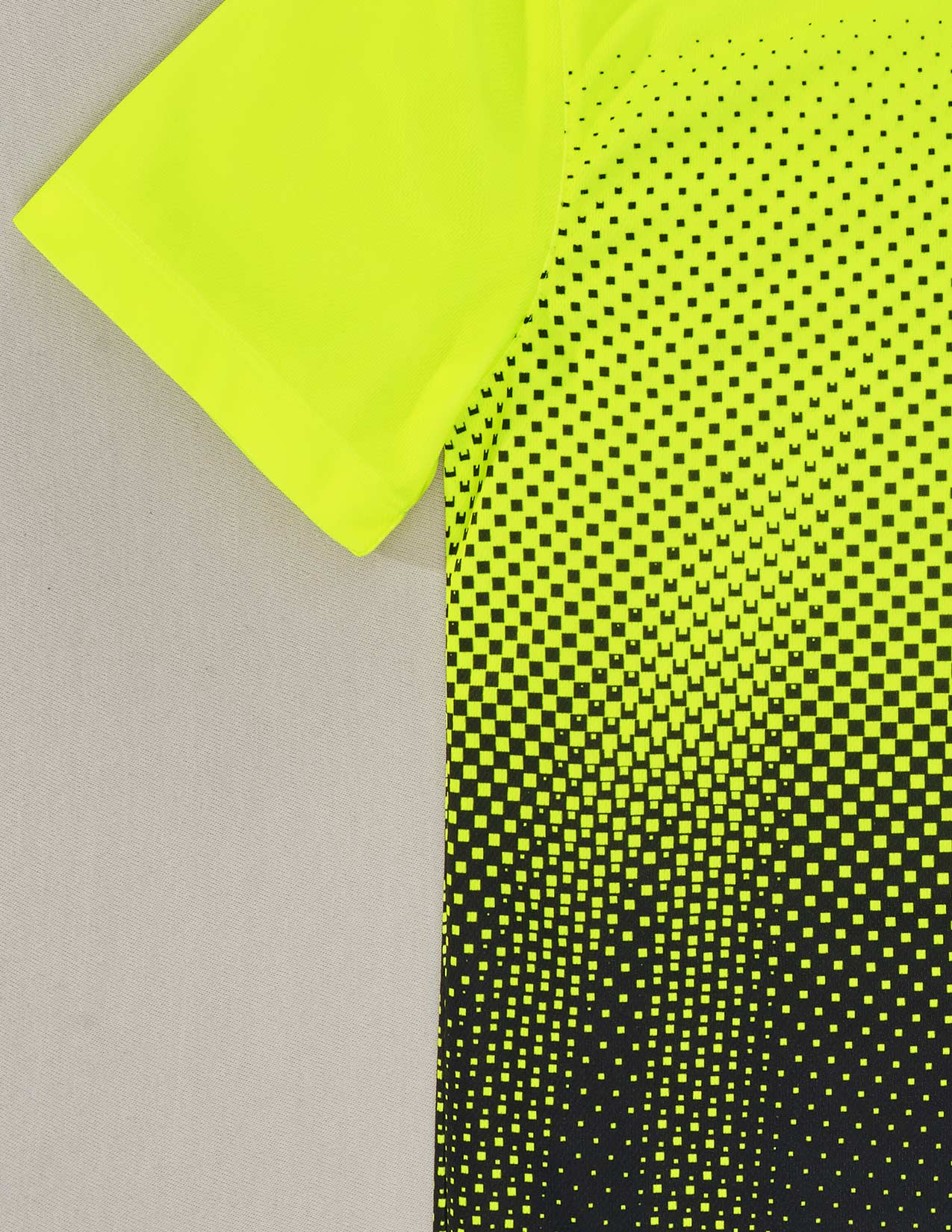 Neon yellow t-shirt with black dot pattern on a gray background