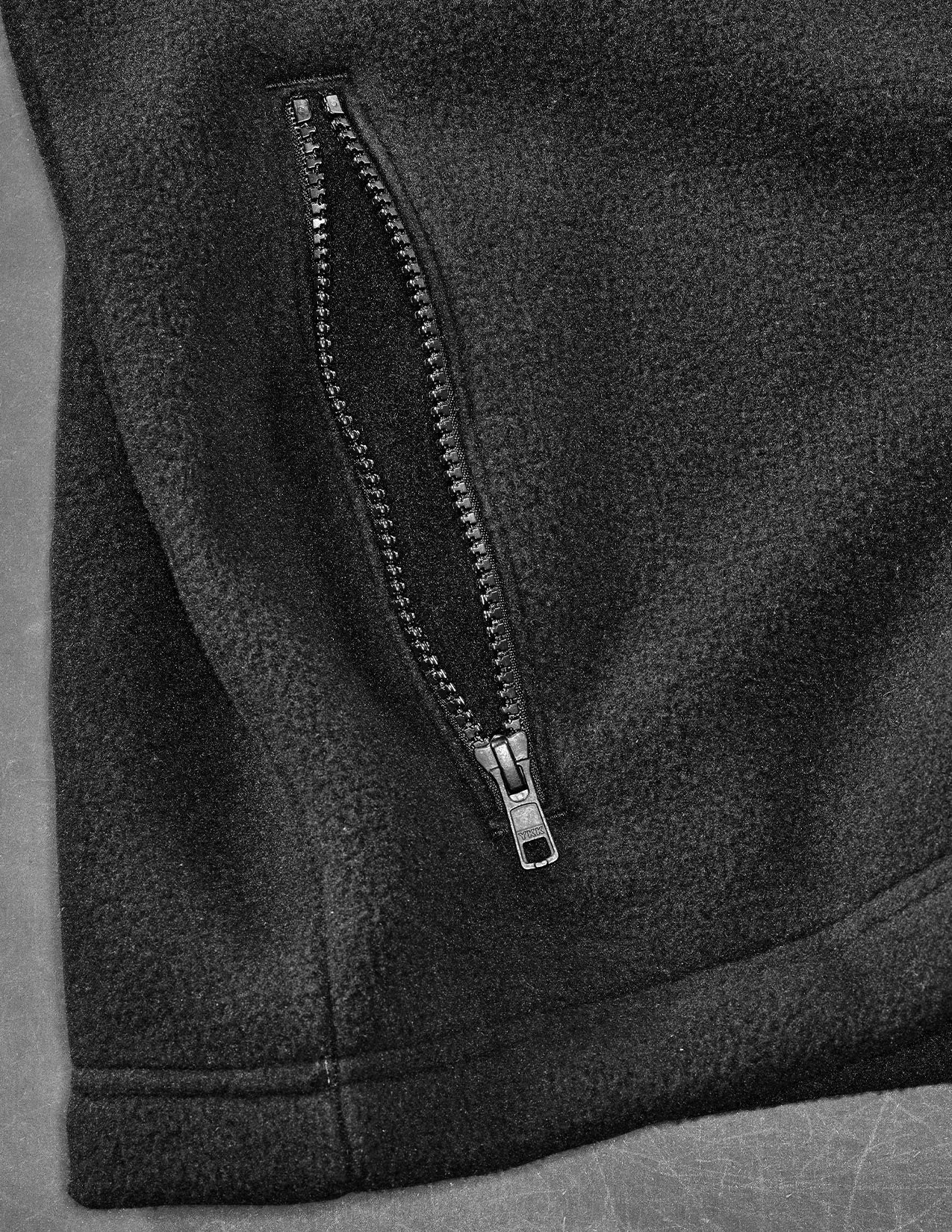 Close-up of a black zipper on a textured fabric surface