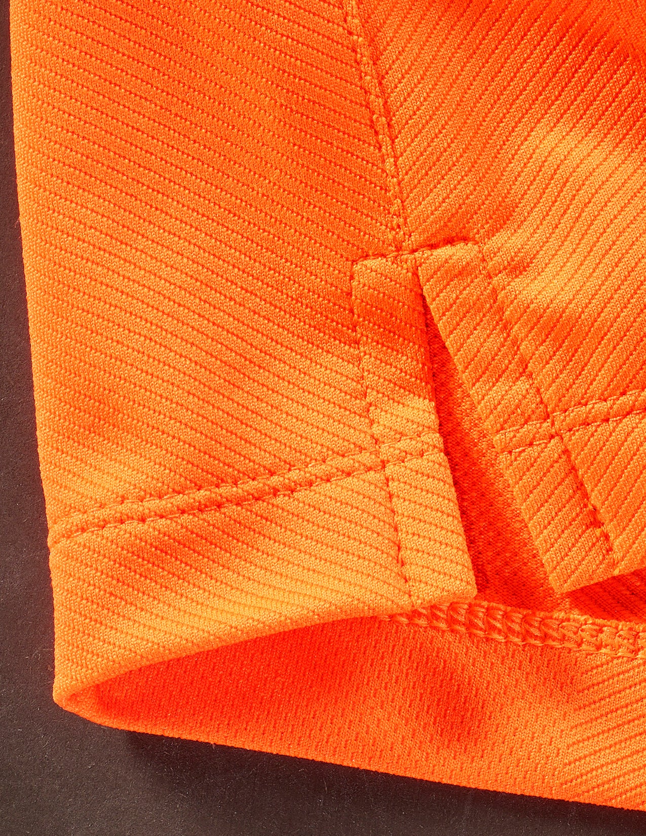 Close-up of bright orange fabric with a textured pattern