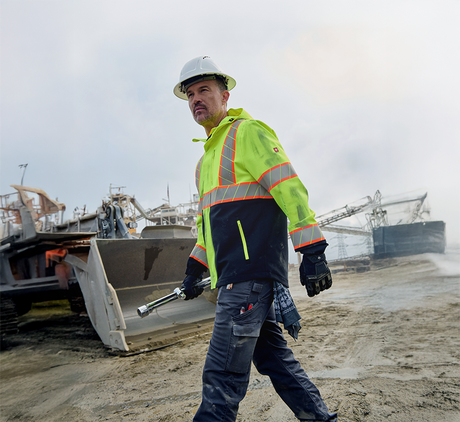 Man in high visibility jacket walks job site