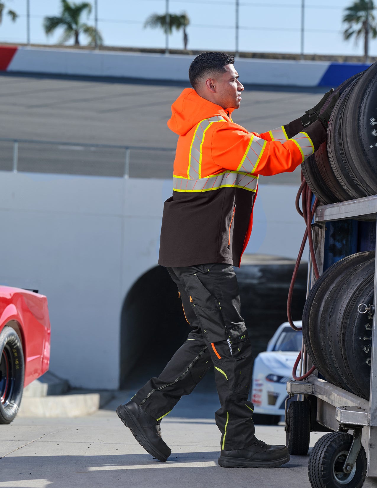 Person in high-visibility clothing working on a vehicle tire