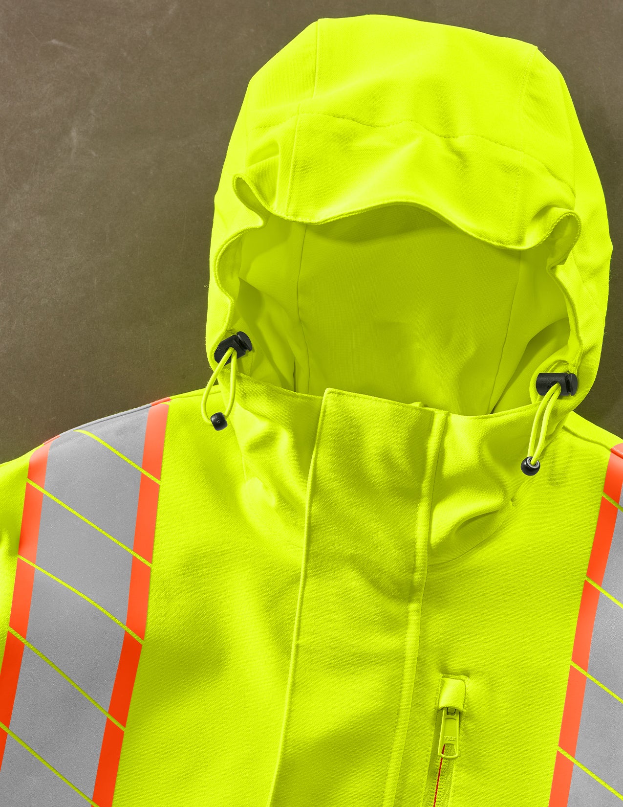 High-visibility safety jacket with reflective stripes on a plain background