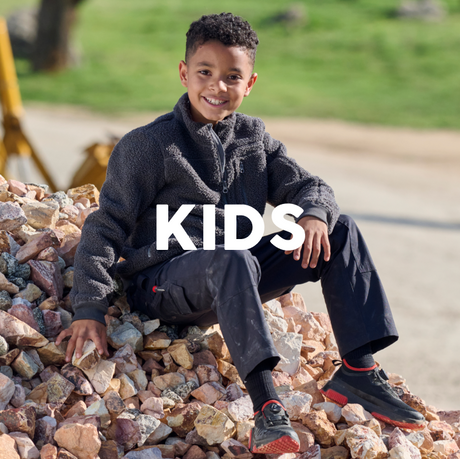 Child sitting on rocks with 'KIDS' text overlay