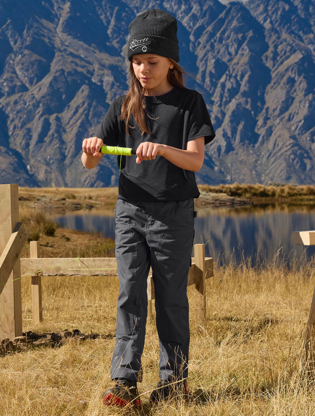 Child standing in a field with mountains in the background
