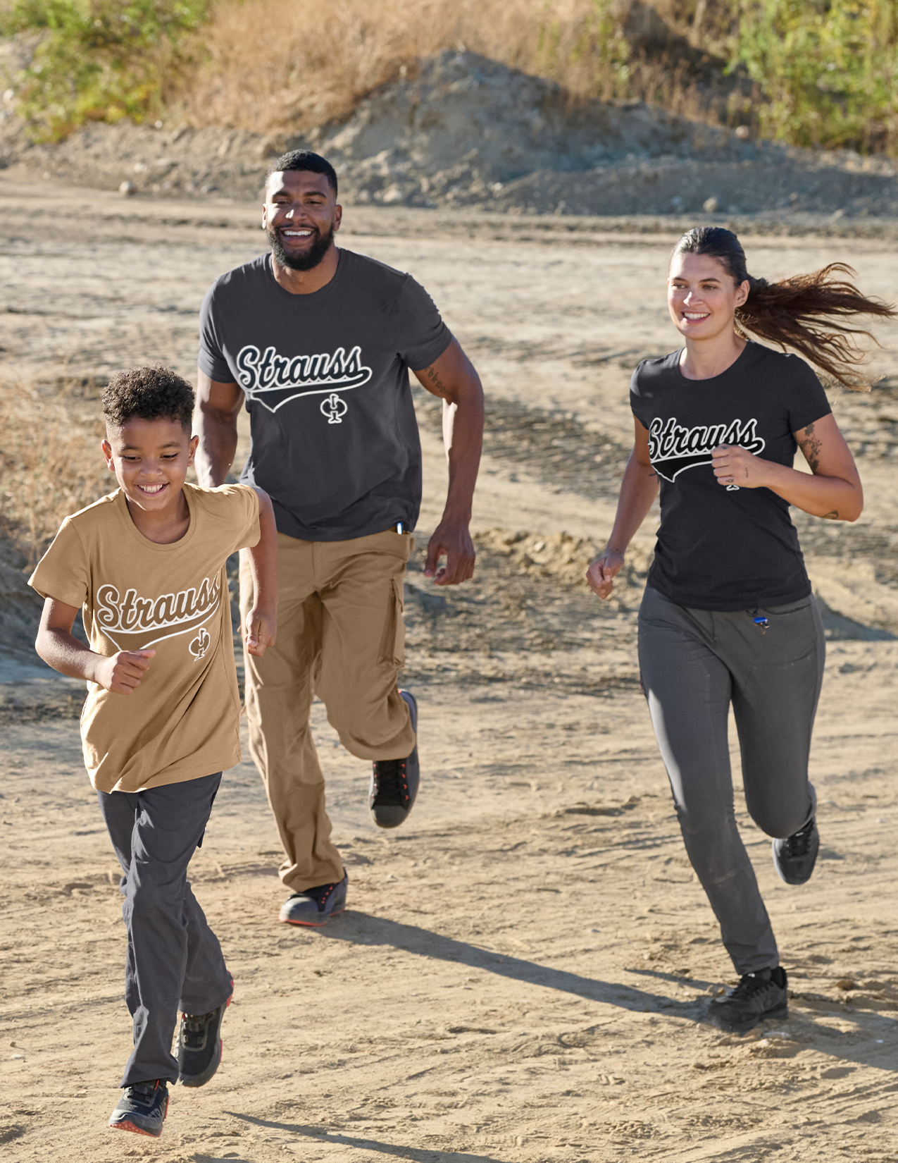 Family running outdoors wearing Strauss t-shirts.