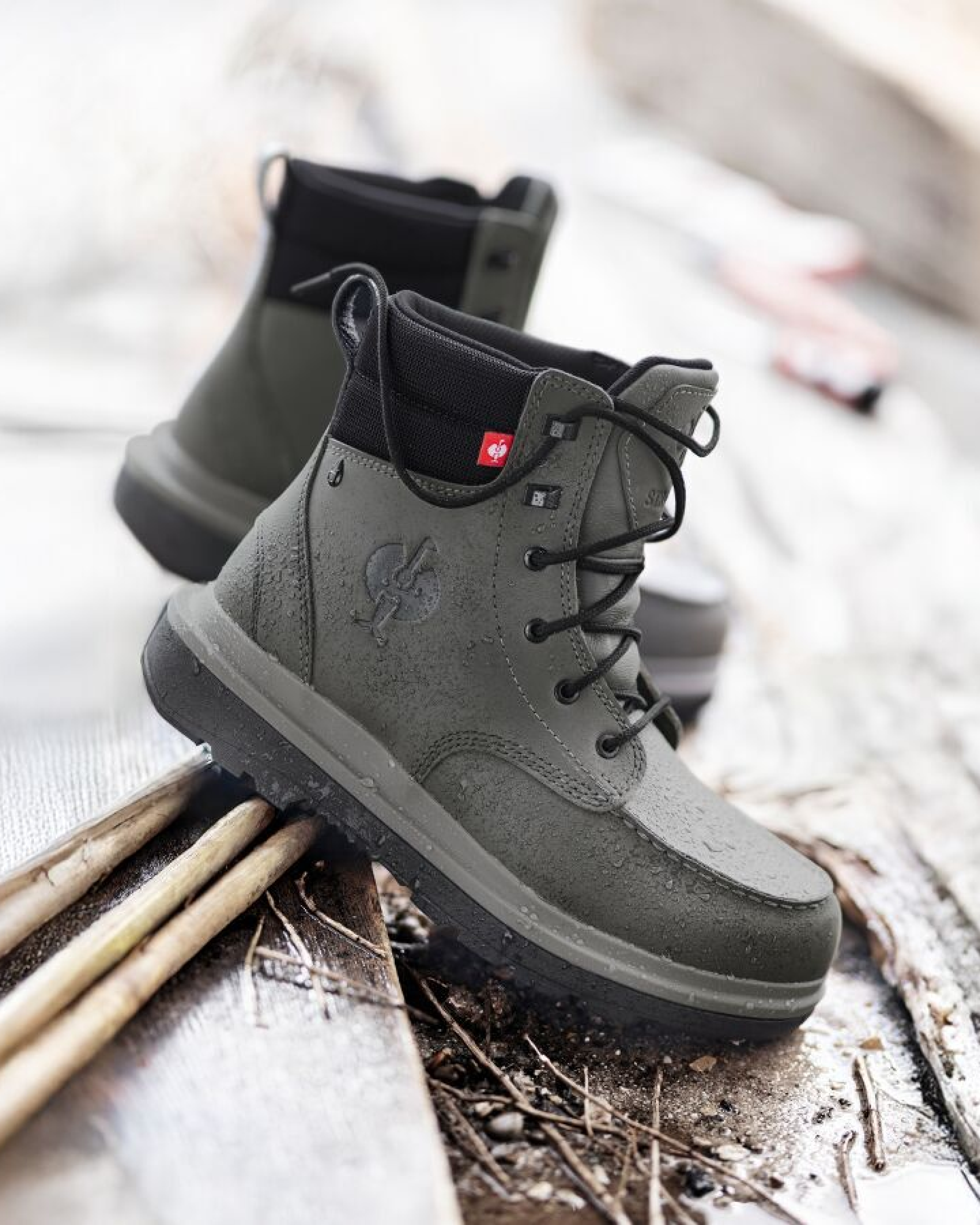 Gray boots with black soles on a wooden surface