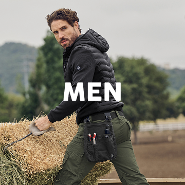 Man working with hay in an outdoor setting, wearing a black jacket and green pants.