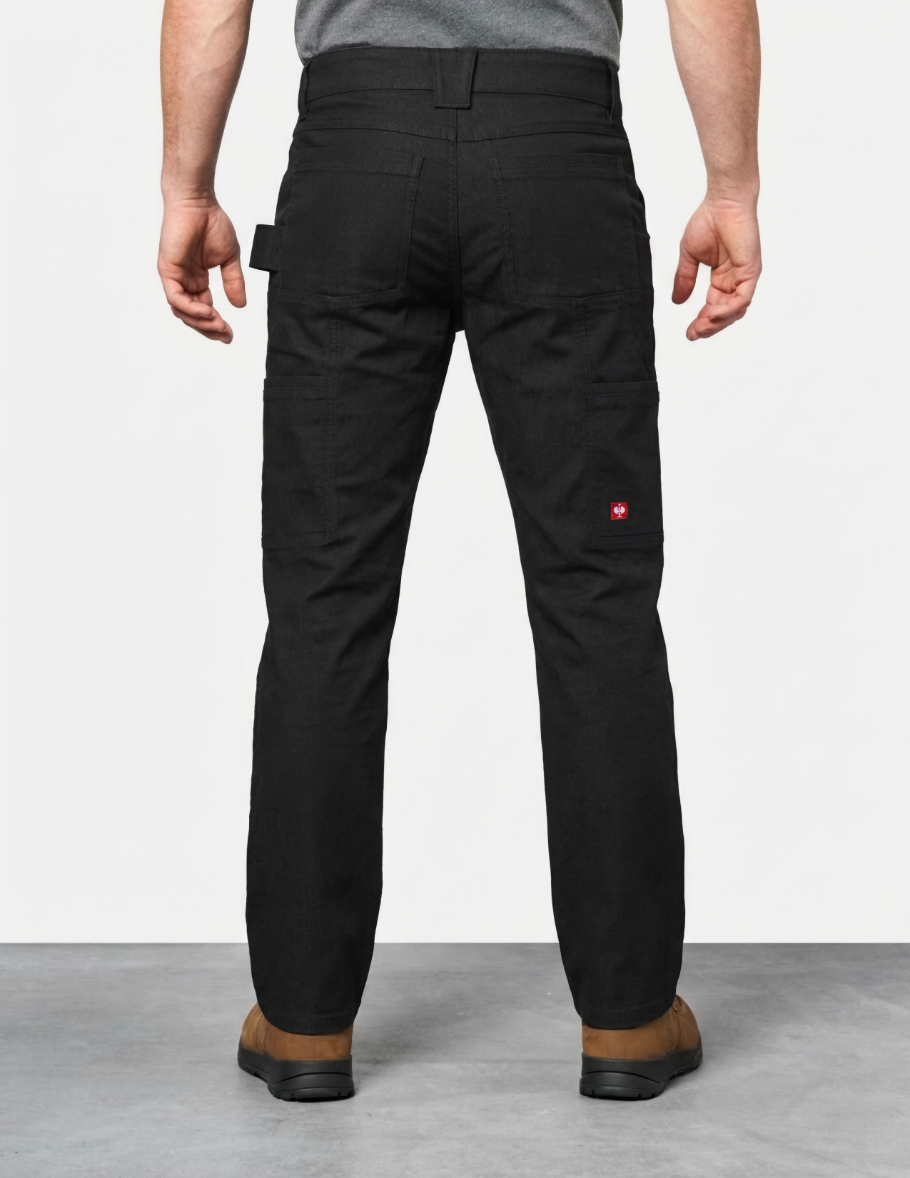 Person wearing black pants with a visible brand logo on a white background