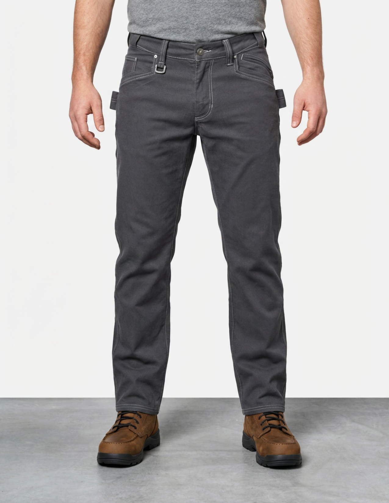Person wearing gray pants and brown shoes on a plain background