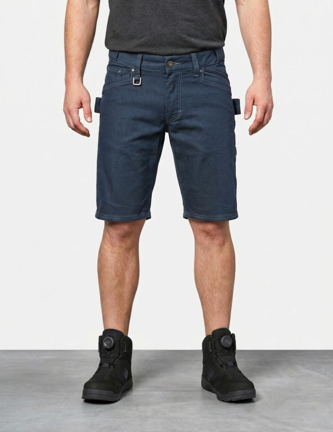 Person wearing blue shorts and black boots on a white background