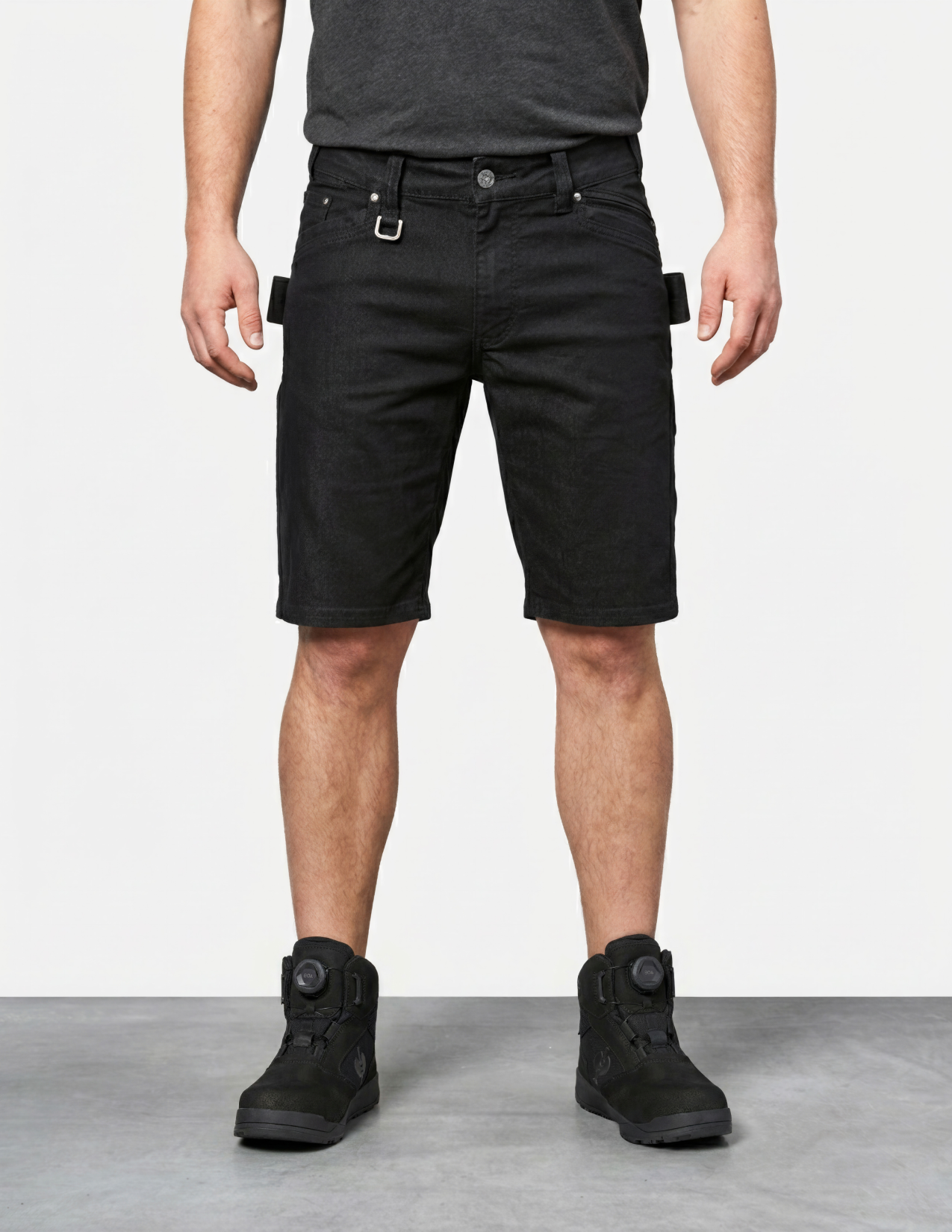 Person wearing black shorts and black boots on a white background