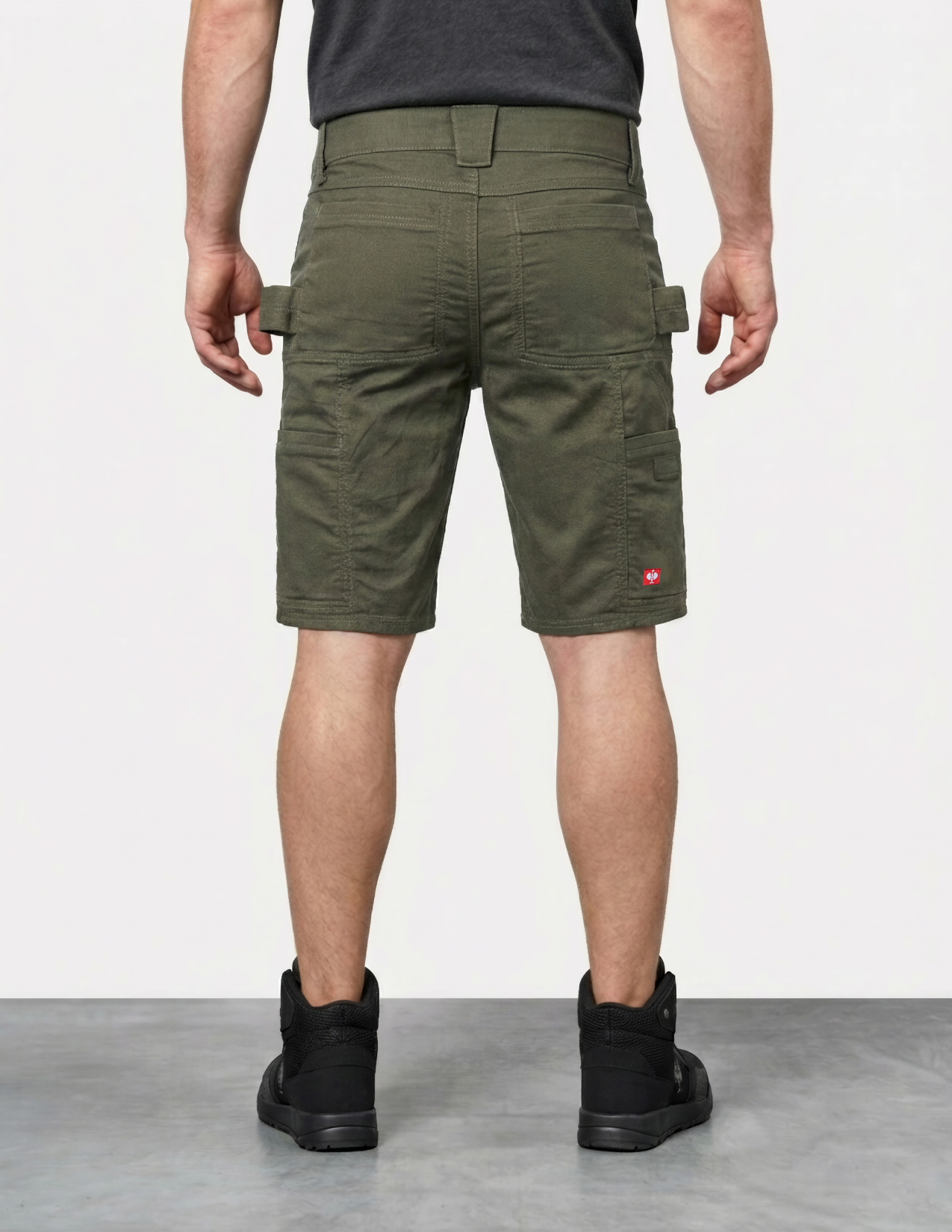 Person wearing green cargo shorts on a plain background