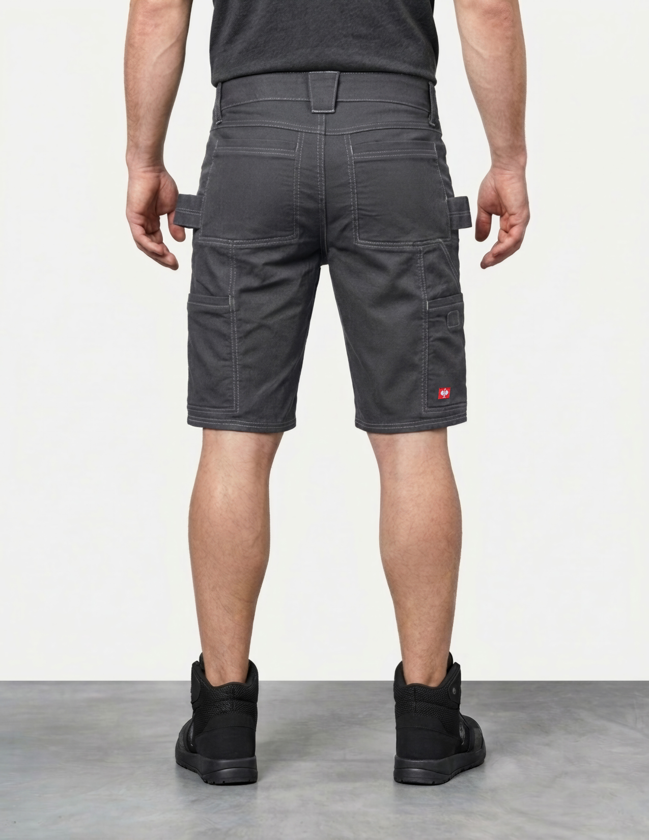 Person wearing dark gray cargo shorts on a plain background