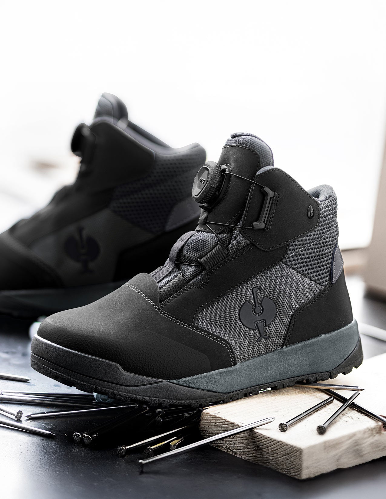 Black and gray high-top boots on a wooden block with nails in the background