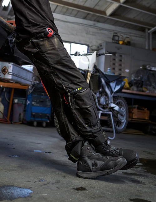 a person's legs in black pants and boots