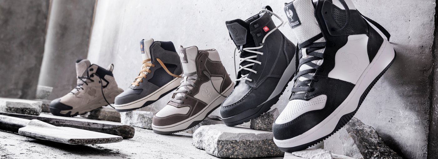 Five pairs of high-top sneakers in various neutral colors are displayed on concrete slabs against a gray industrial background.