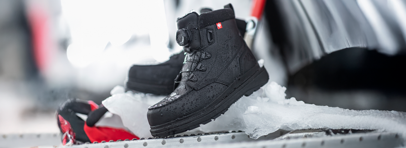 Black winter boots on a snowy surface with blurred background