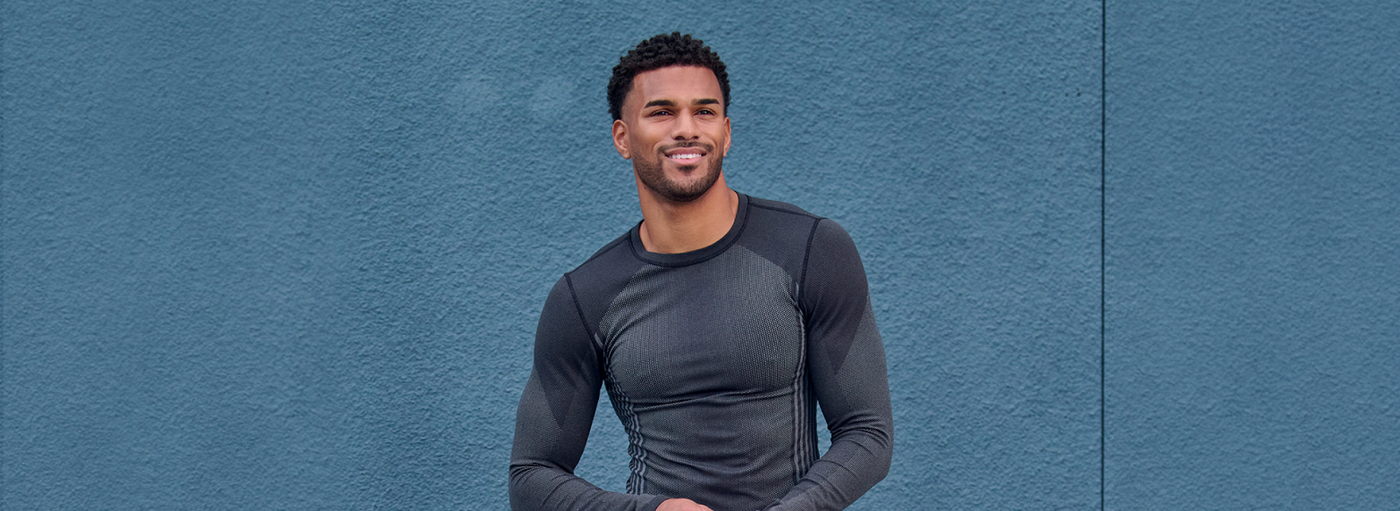Man wearing a black long-sleeve shirt against a blue background