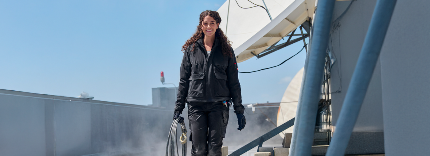 Person standing on a rooftop with a clear blue sky
