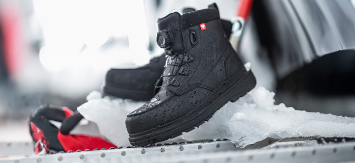 Black winter boots with red accents on a snowy surface