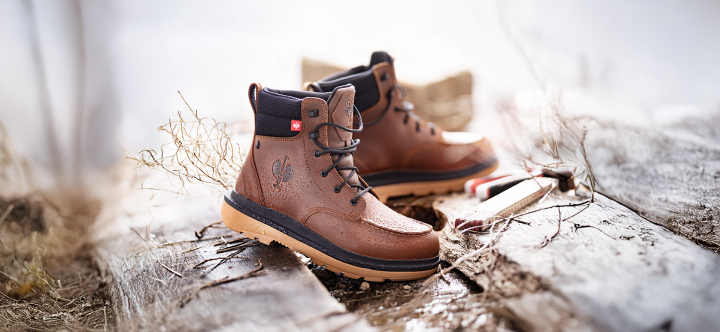 Pair of brown boots with black soles on a natural background