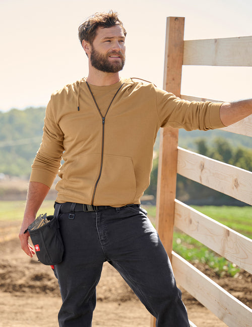 a man leaning against a fence