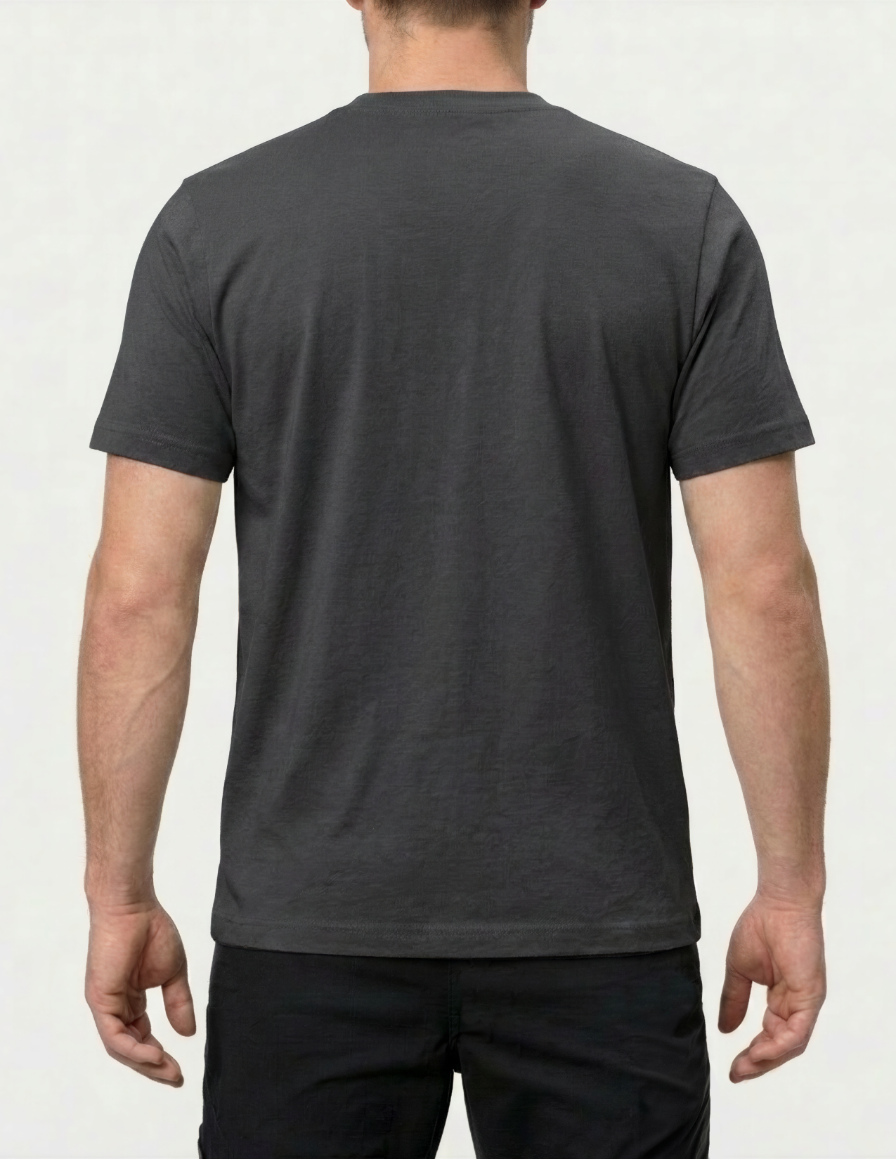 Person wearing a plain dark gray t-shirt on a light gray background