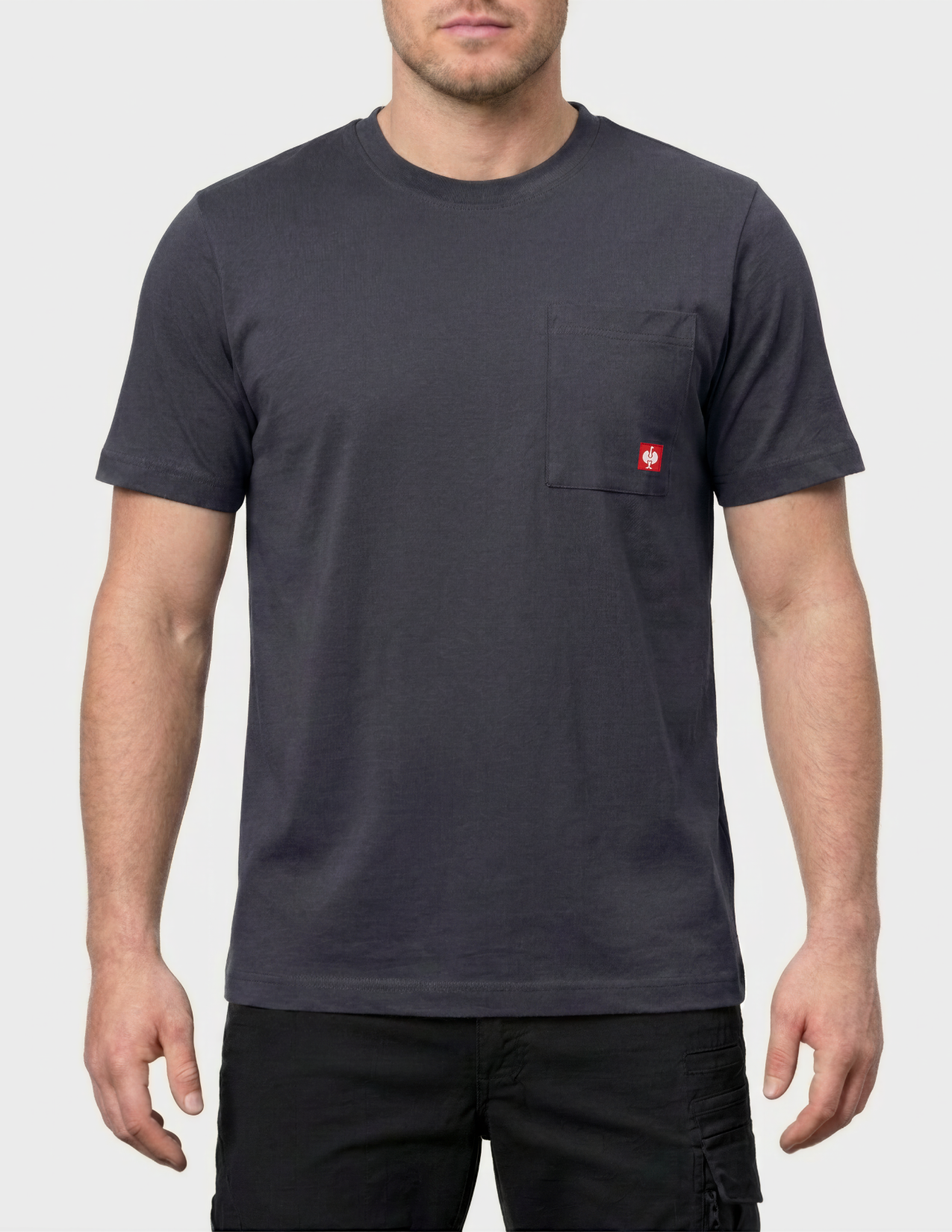 Person wearing a dark gray t-shirt with a small red logo on a white background