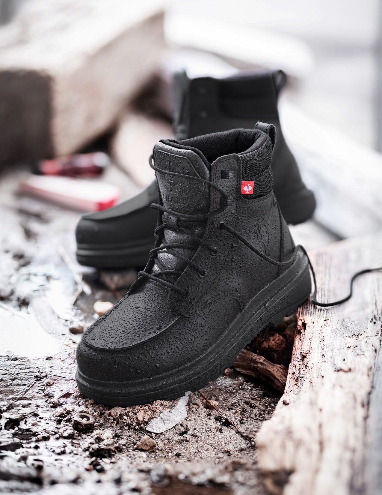 Black boots with a red label on a textured surface