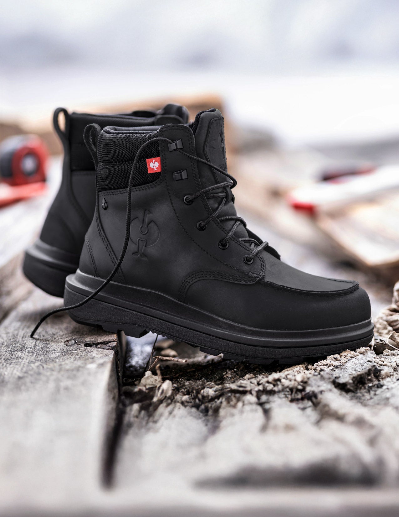 Black boots with a brand logo on a textured surface