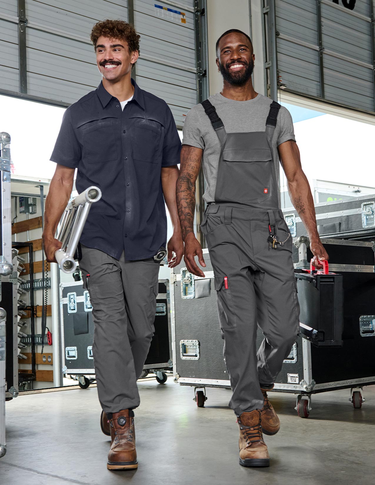 Two men in work attire walking through a warehouse.