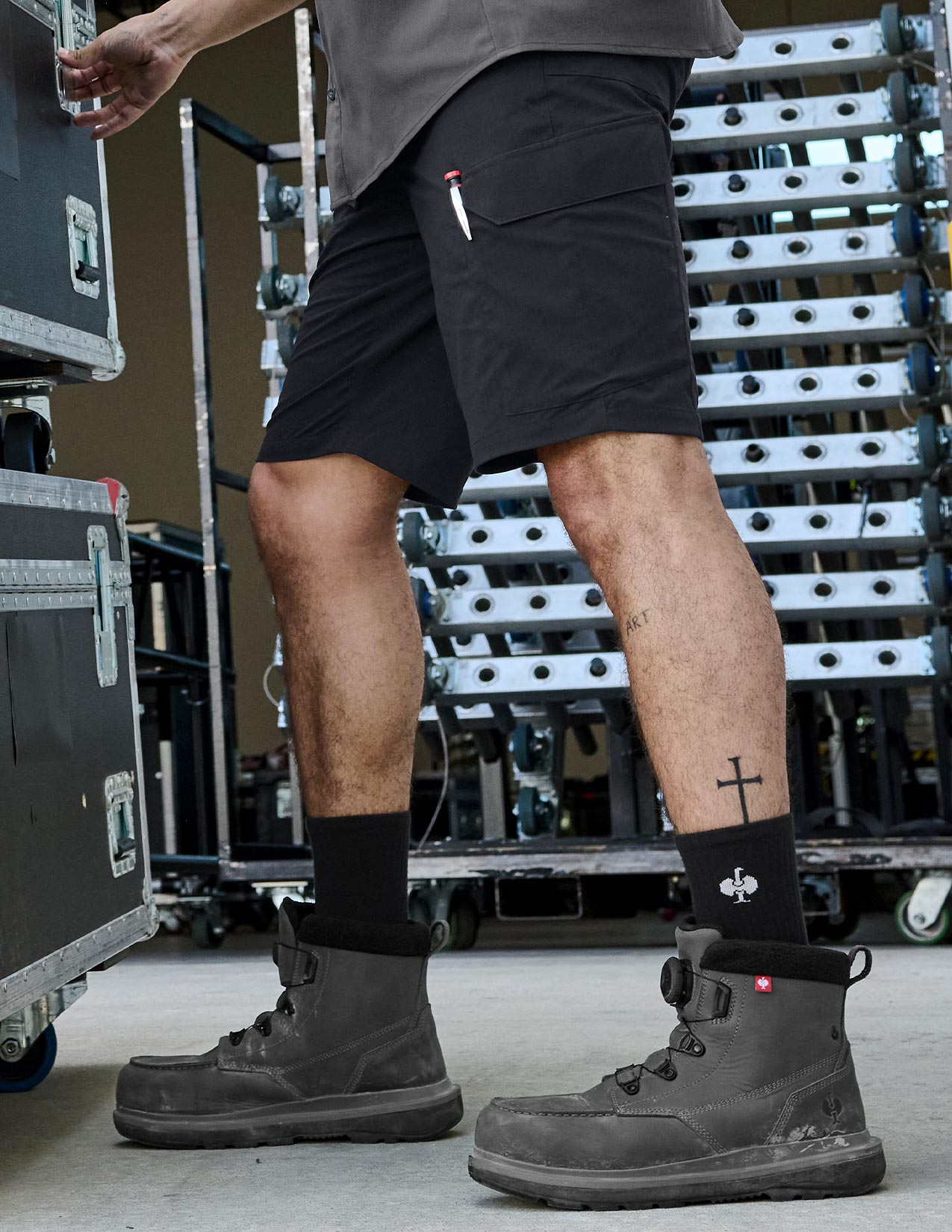 Person wearing black shorts and boots in a warehouse setting