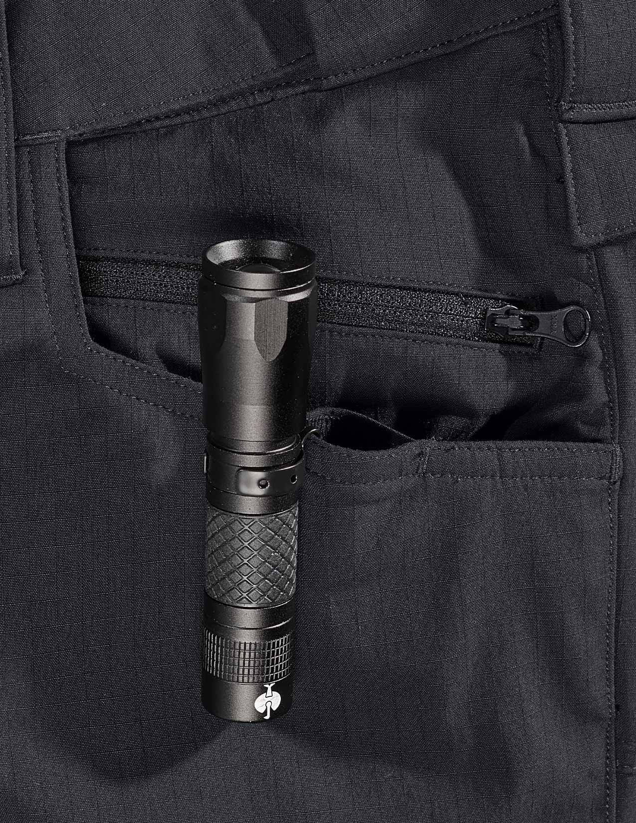 Black flashlight in a pocket of a black short